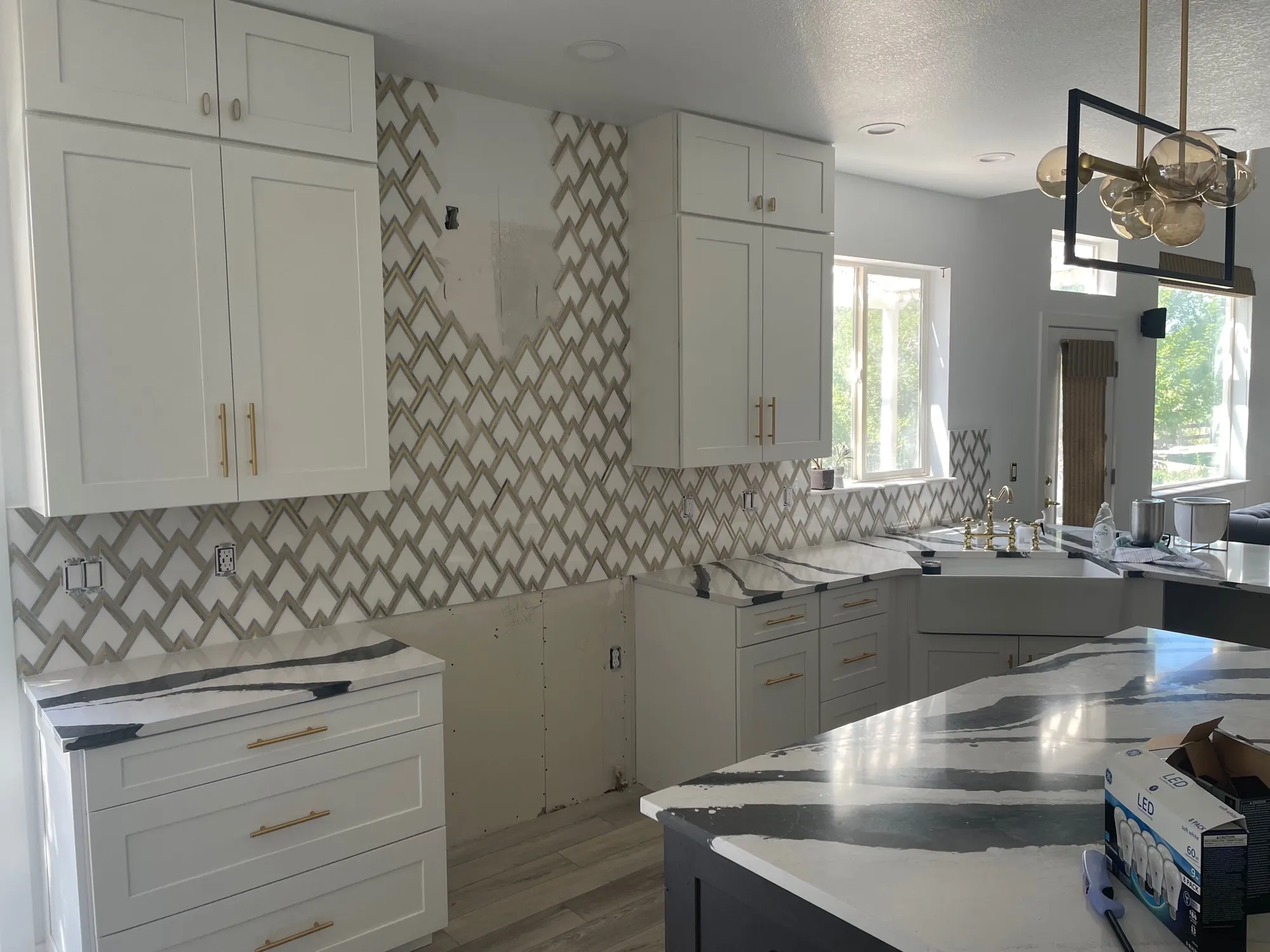 Marble trellis mosaic backsplash paired with a black-and-white marble island